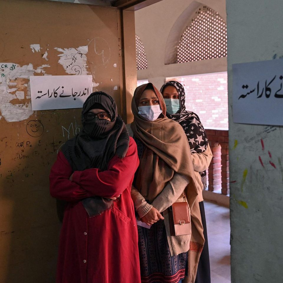Lahore, Pakistan.  Three women stand in line at a polling station, a little shy.  Parliamentary and four provincial elections are taking place in Pakistan today.  Around 128 million people are allowed to go to the polls.  In total, almost 18,000 candidates stood at more than 90,000 polling stations.  However, pollsters expect that voter turnout will be limited.